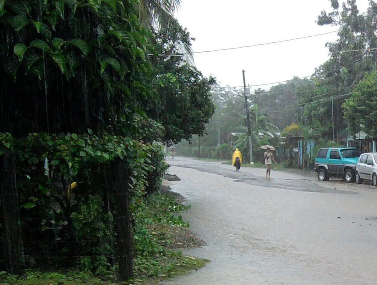 El estado del tiempo se ve en lo que hace la gente: capa amarilla, sombrilla y nadie caminando por el medio de la calle, porque el agua va corriendo. Imagen de Wikimedia Commons, MadriCR, CC BY-SA 3.0.