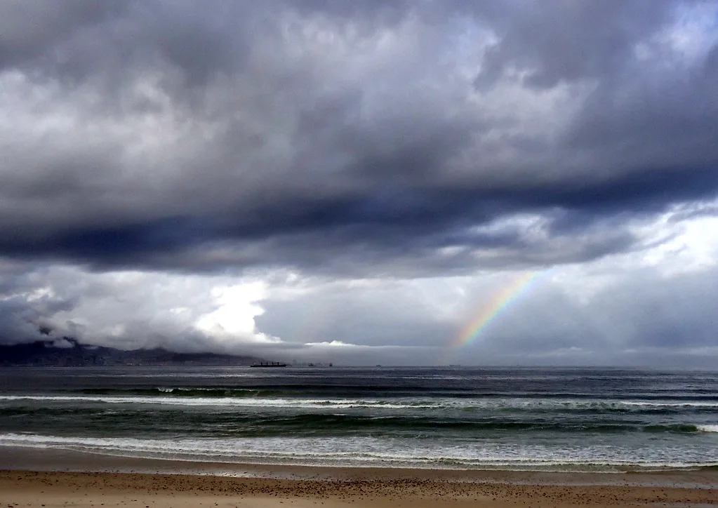 Un arcoíris sobre el mar, tras una tormenta. Se forma cuando la luz blanca del sol atraviesa las gotas de lluvia y se separa en los colores que ya traía mezclados: rojo, naranja, amarillo, verde, azul, añil y violeta. Fotografía de Flickr, barbourians, licencia BY.