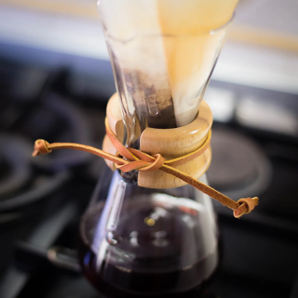 Café colado con un filtro de papel: el líquido oscuro pasa, y el café molido queda atrapado arriba. Es una separación por filtración, el método que sirve cuando un componente de la mezcla es sólido y el otro, líquido. Fotografía de Nicola, Flickr, CC BY.