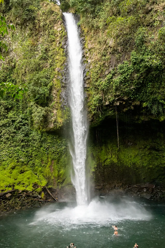 La catarata de La Fortuna, en Costa Rica. Arriba, antes de caer, el agua tiene energía potencial por su altura; mientras cae se convierte en energía cinética, la del movimiento, que es la que agita la poza de abajo. Fotografía de Flickr, dconvertini, licencia BY-SA.