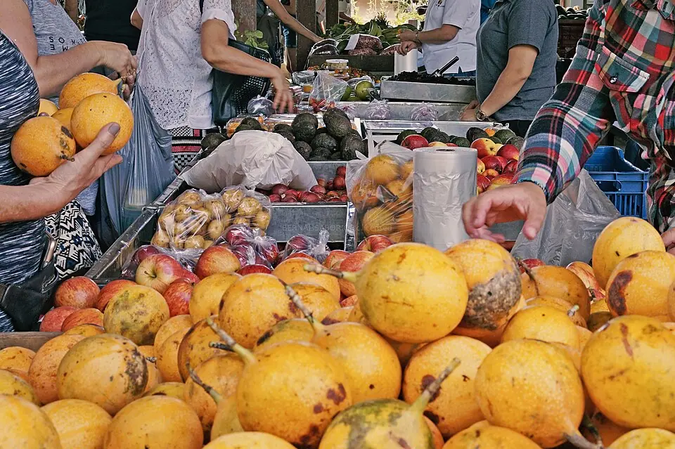 Puesto de frutas en una feria del agricultor de Costa Rica, con granadillas al frente y manzanas y aguacates detrás. En la feria se resuelven problemas de proporción todos los días: si un kilo cuesta tanto, cuánto cuestan tres, y cuánto se ahorra con la rebaja. Imagen de Wikimedia Commons, Bernal Saborío, CC BY-SA 2.0.