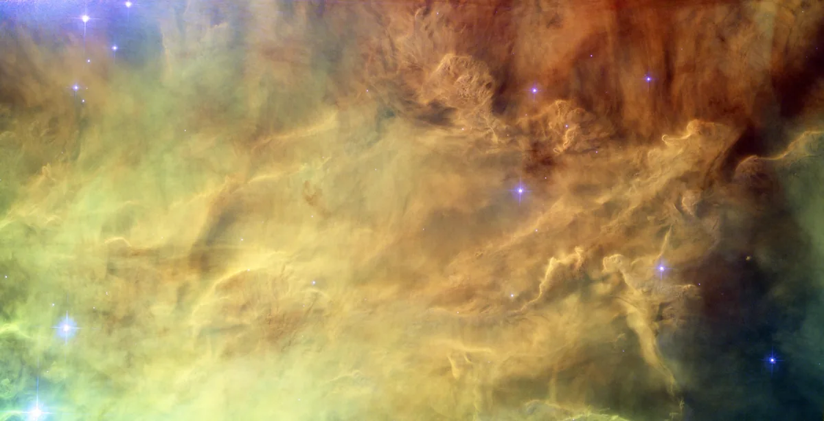 El corazón de la Nebulosa de la Laguna, fotografiado por el telescopio espacial Hubble. Una nebulosa es una nube enorme de gas y polvo, y los puntos brillantes que se ven aquí son estrellas nuevas formándose dentro de ella. Imagen de la NASA, dominio público.