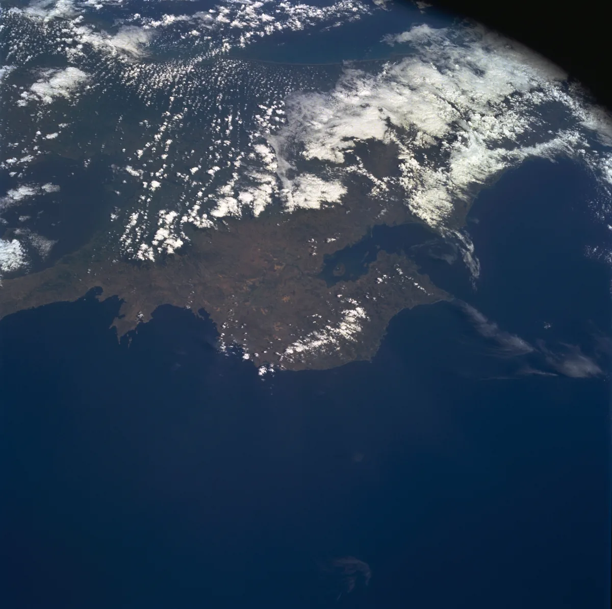 Costa Rica fotografiada desde el transbordador espacial en 1994: abajo se ven la península de Nicoya y su golfo, y hacia adentro la nubosidad apilada sobre las montañas. Esa diferencia es la clase de rasgo con que se traza una región: a un lado de la cordillera llueve distinto que al otro. Imagen de la NASA, dominio público.