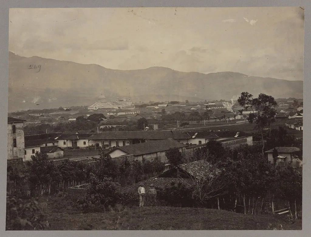San José a finales del siglo XIX: casas bajas de teja, tapias, y al fondo las cúpulas de un templo y las montañas del valle. Esta es la ciudad donde los liberales instalaron el Estado que venían a construir. Fotografía de la Biblioteca del Congreso de Estados Unidos, dominio público.