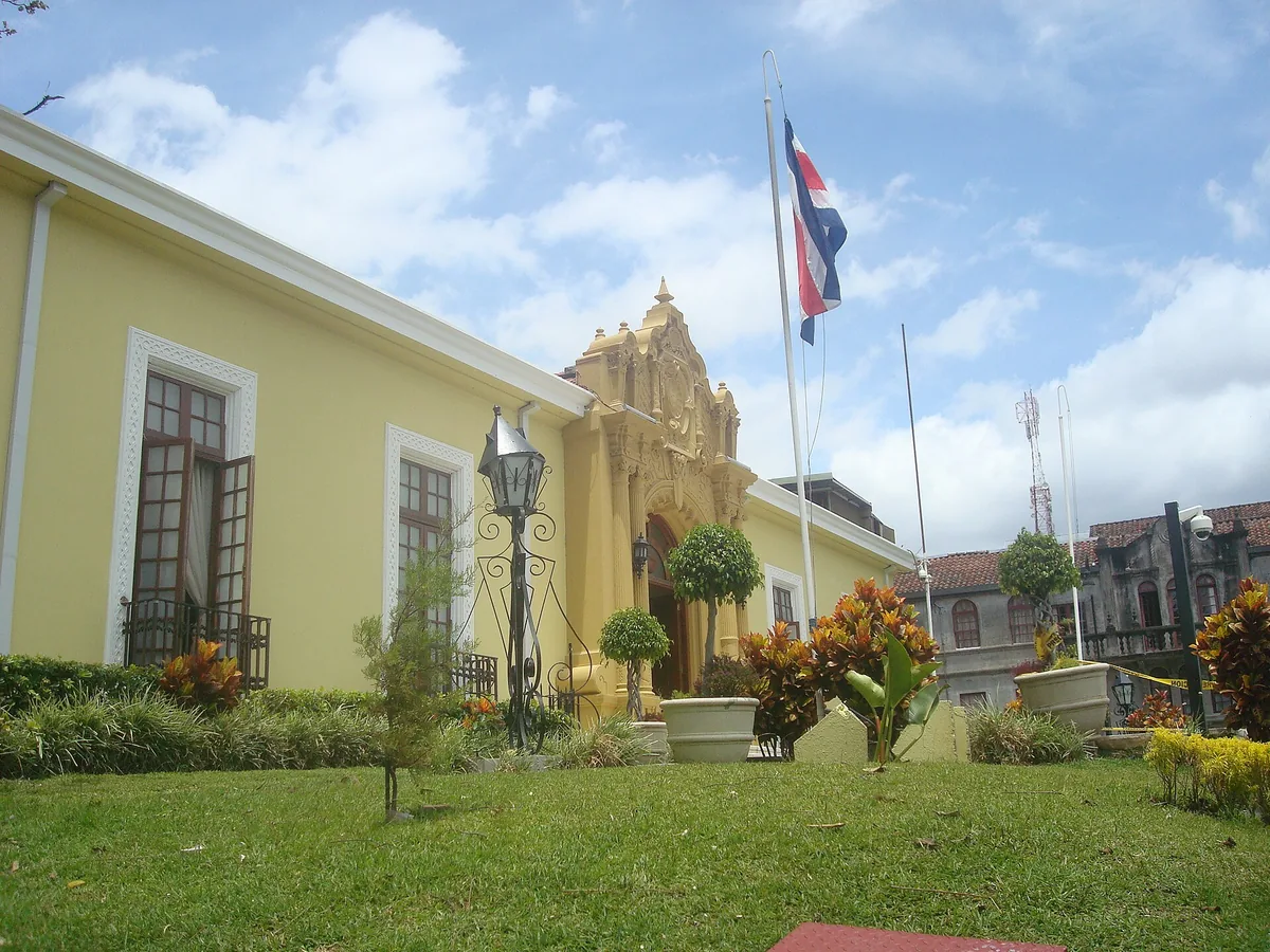 La bandera de Costa Rica ondea sobre la Casa Amarilla, sede de la Cancillería, en San José. Las cinco franjas horizontales, con la roja al centro y más ancha, son el diseño que se fijó por decreto el 29 de setiembre de 1848. Foto: Rodtico21, Wikimedia Commons (CC BY-SA 2.0).