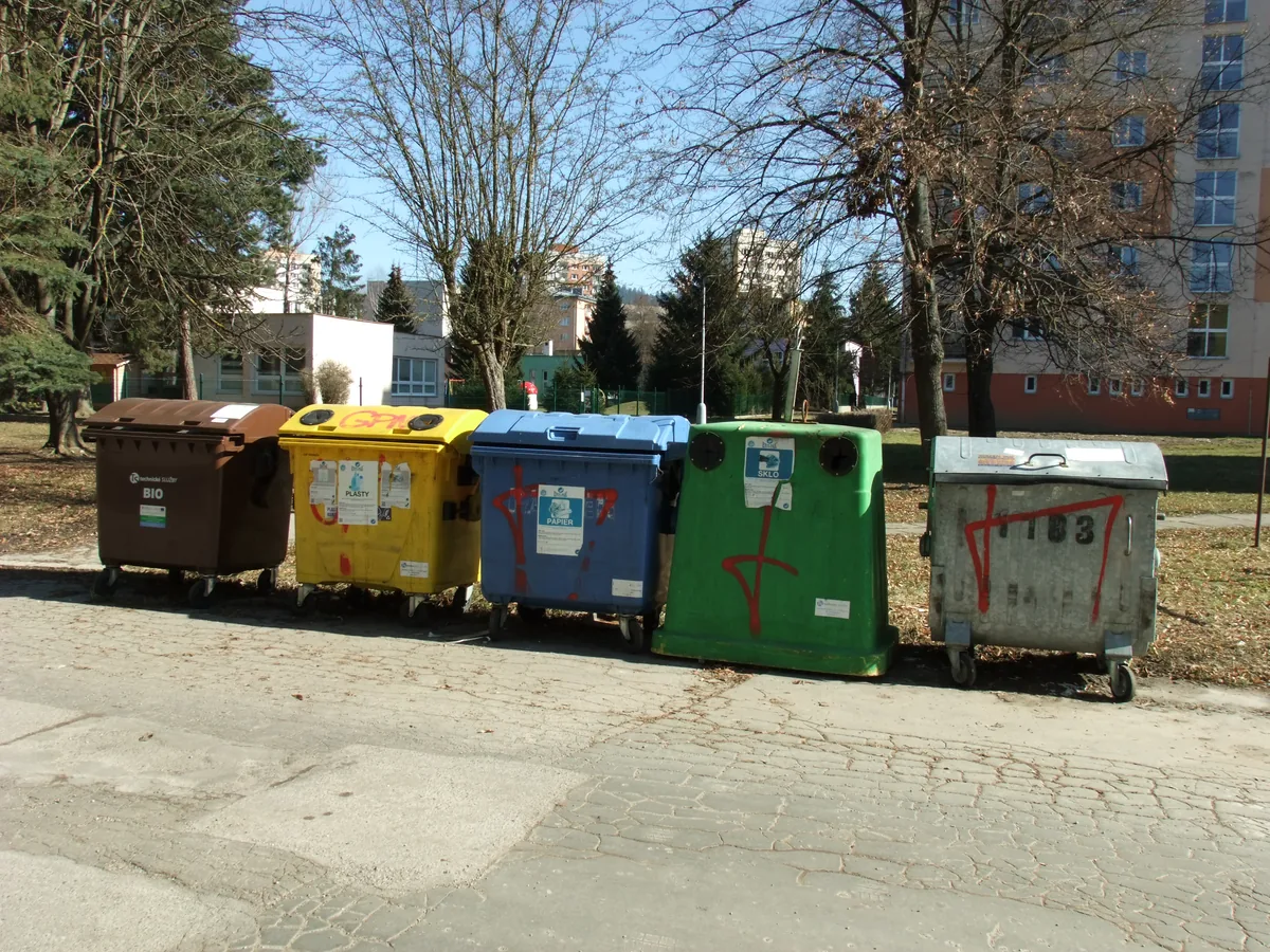 Contenedores de basura separados por colores, cada uno para un tipo distinto de residuo. Separar así antes de tirar es lo que permite que el papel, el vidrio o el plástico se valoricen en vez de terminar todos juntos en el relleno sanitario. Foto: Oto Zapletal, Wikimedia Commons (CC BY-SA 4.0).