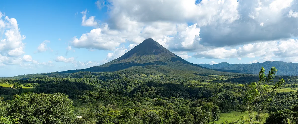 El volcán Arenal, visto desde la llanura de San Carlos. Su erupción del 29 de julio de 1968, cuando se creía apagado, cambió la región dos veces: obligó a reordenar los poblados y, con los años, lo convirtió en el motor turístico de la zona. Foto: Rhododendrites, Wikimedia Commons (CC BY-SA 4.0).