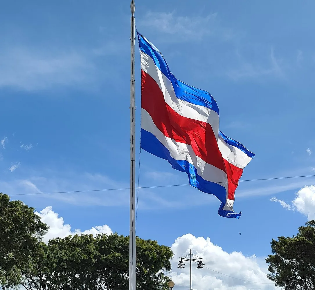 La bandera de Costa Rica en la Plaza Mayor de Cartago. Cuando alguien te pregunta Where are you from?, esta es tu respuesta: I am from Costa Rica, soy de Costa Rica. Foto: Rubýñ, Wikimedia Commons, CC0 (recortada).