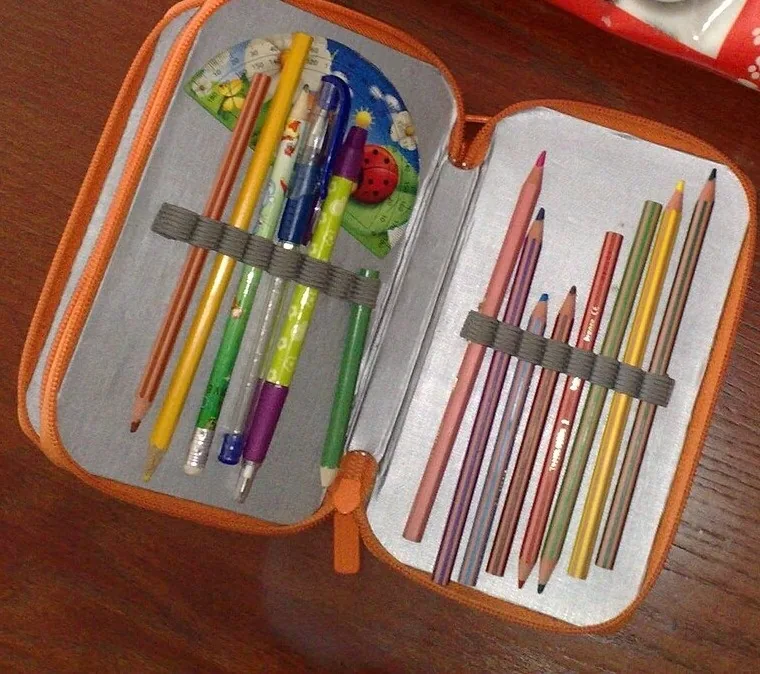 Una cartuchera abierta, the pencil case: a un lado van los lápices y los lapiceros (pencils, pens) y al otro los lápices de color (colored pencils). Así se guardan los útiles para que no se pierdan. Foto: ABX, Wikimedia Commons, CC BY-SA 4.0 (recortada).