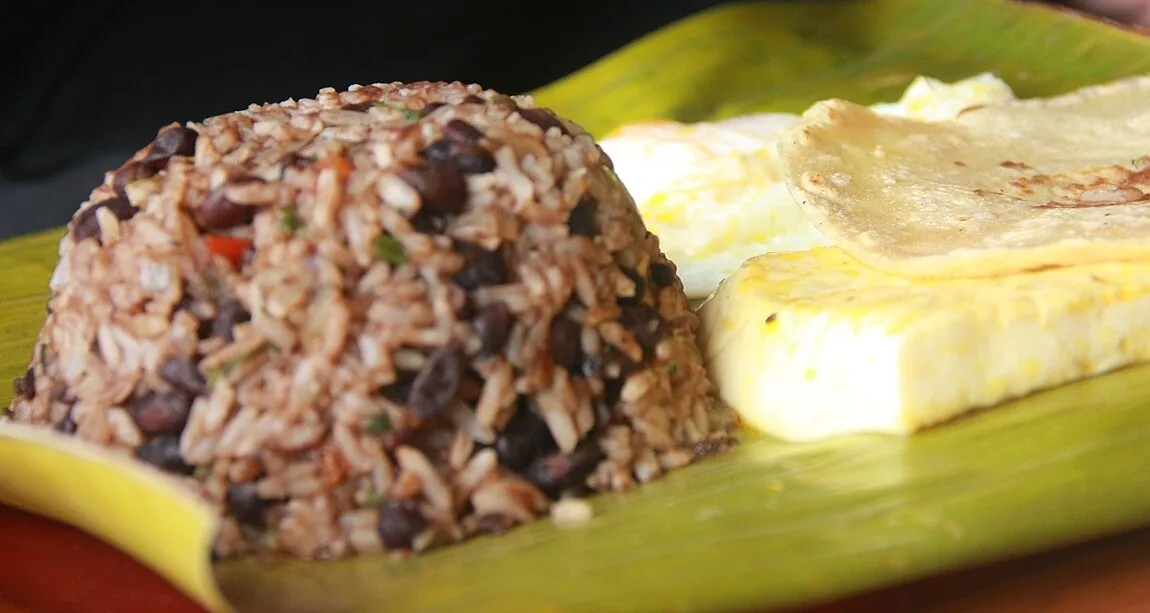 Gallo pinto con huevo y tortilla sobre una hoja de plátano, el desayuno tico. My dad likes to cook gallo pinto: a mi papá le gusta cocinar gallo pinto. Foto: Legendre17, Wikimedia Commons, CC BY 3.0 (recortada).