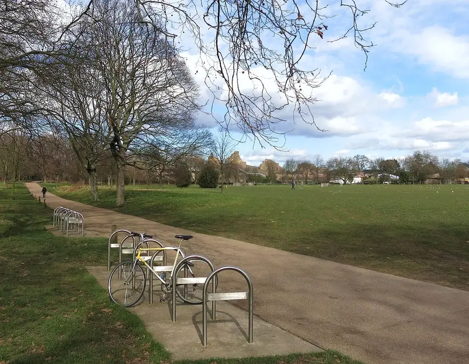 Una bicicleta parqueada junto al camino de un parque. Andar en bici es ejercicio: I can ride a bike, puedo andar en bici. Foto: Des Blenkinsopp, Wikimedia Commons, CC BY-SA 2.0.