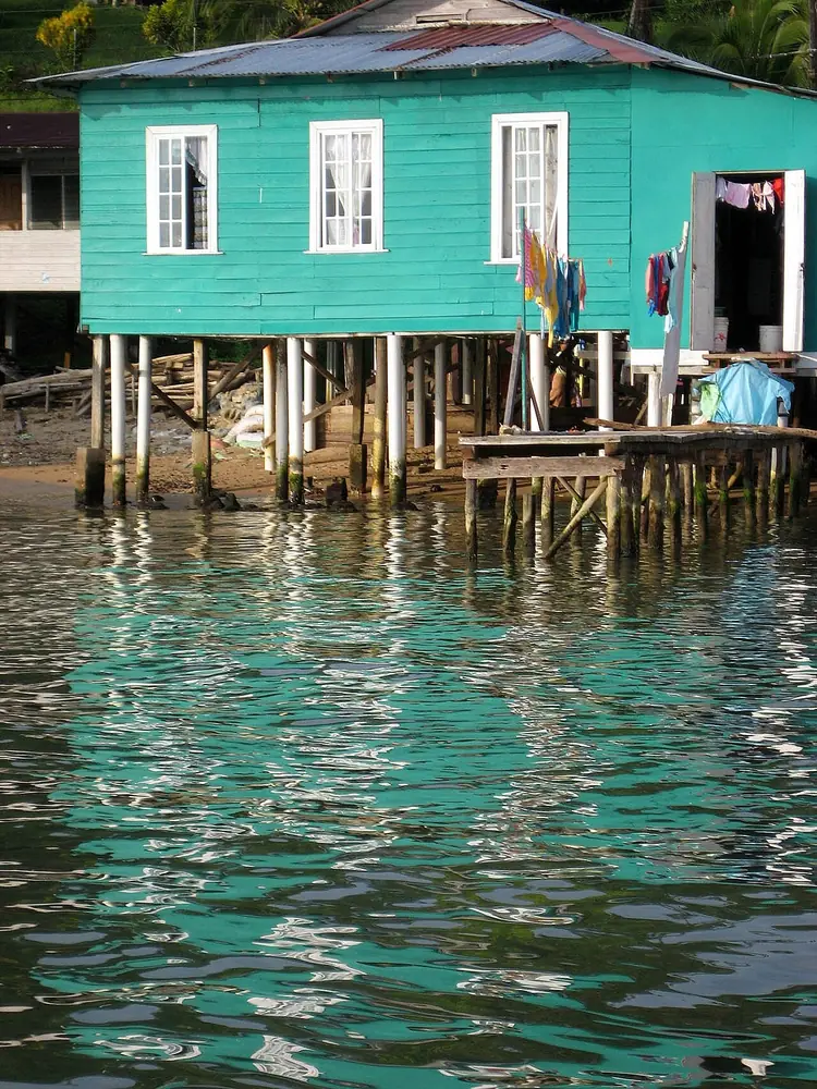 Una casa de madera pintada de celeste, a la orilla del agua. Al recibir a los primos se dice Welcome to my house: bienvenidos a mi casa. Foto: Bernal Saborío, Wikimedia Commons, CC BY-SA 2.0.