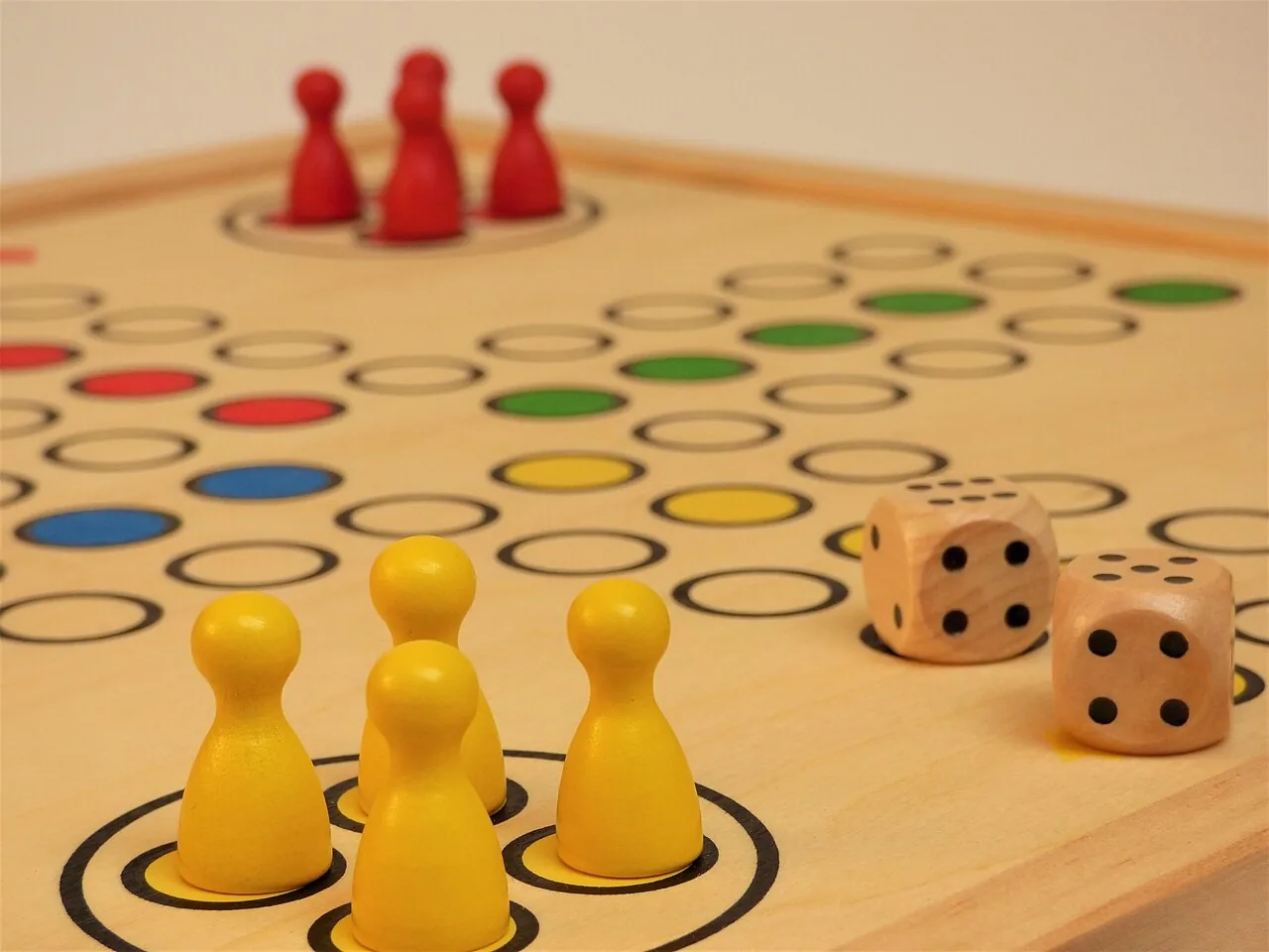 Un juego de mesa con fichas y dos dados. La instrucción roll the dice es tirar el dado. Foto: Tetzemann, Wikimedia Commons, CC0.