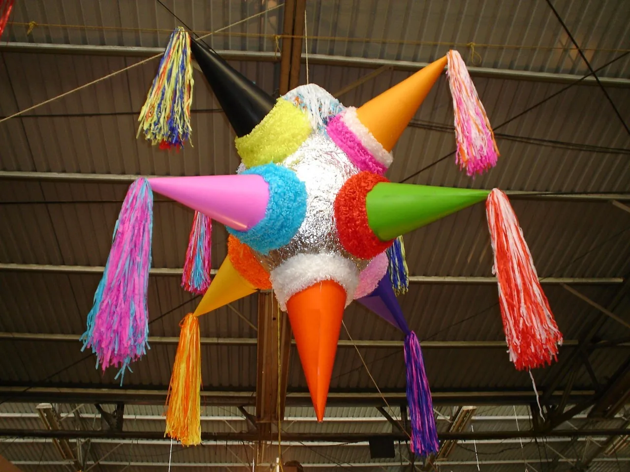 Una piñata de colores colgada para una fiesta. En muchas celebraciones de familia hay piñata. Foto: JED, Wikimedia Commons, dominio público.