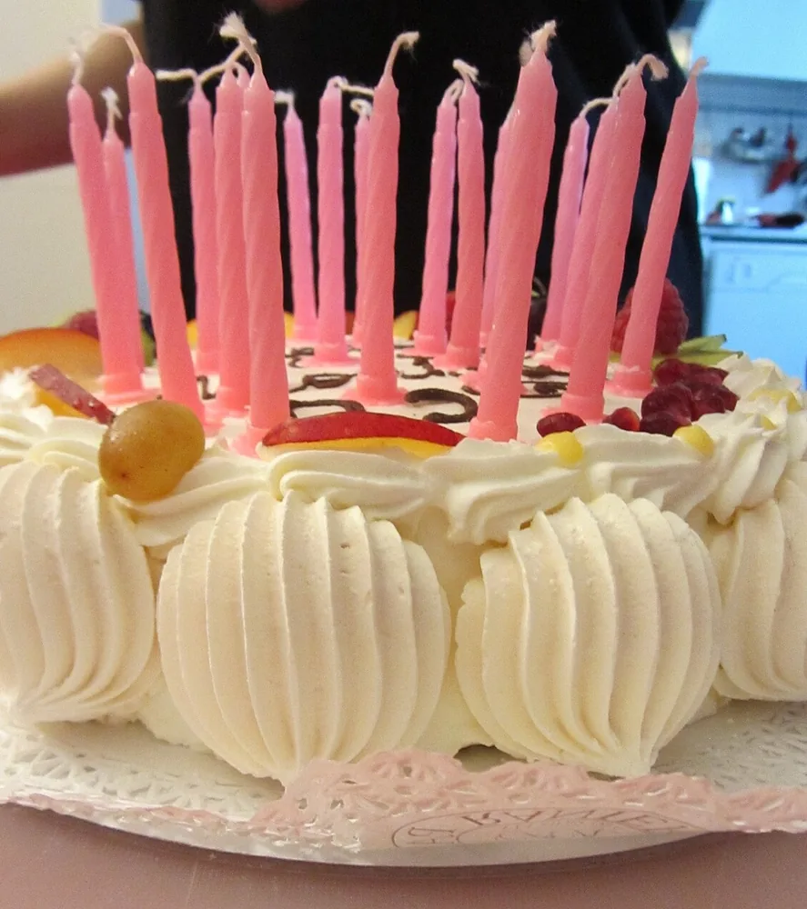 Un queque de cumpleaños con candelas rosadas. En inglés, cake y candles. Foto: Francesca Cesa Bianchi, Wikimedia Commons, CC BY-SA 3.0 (recortada).
