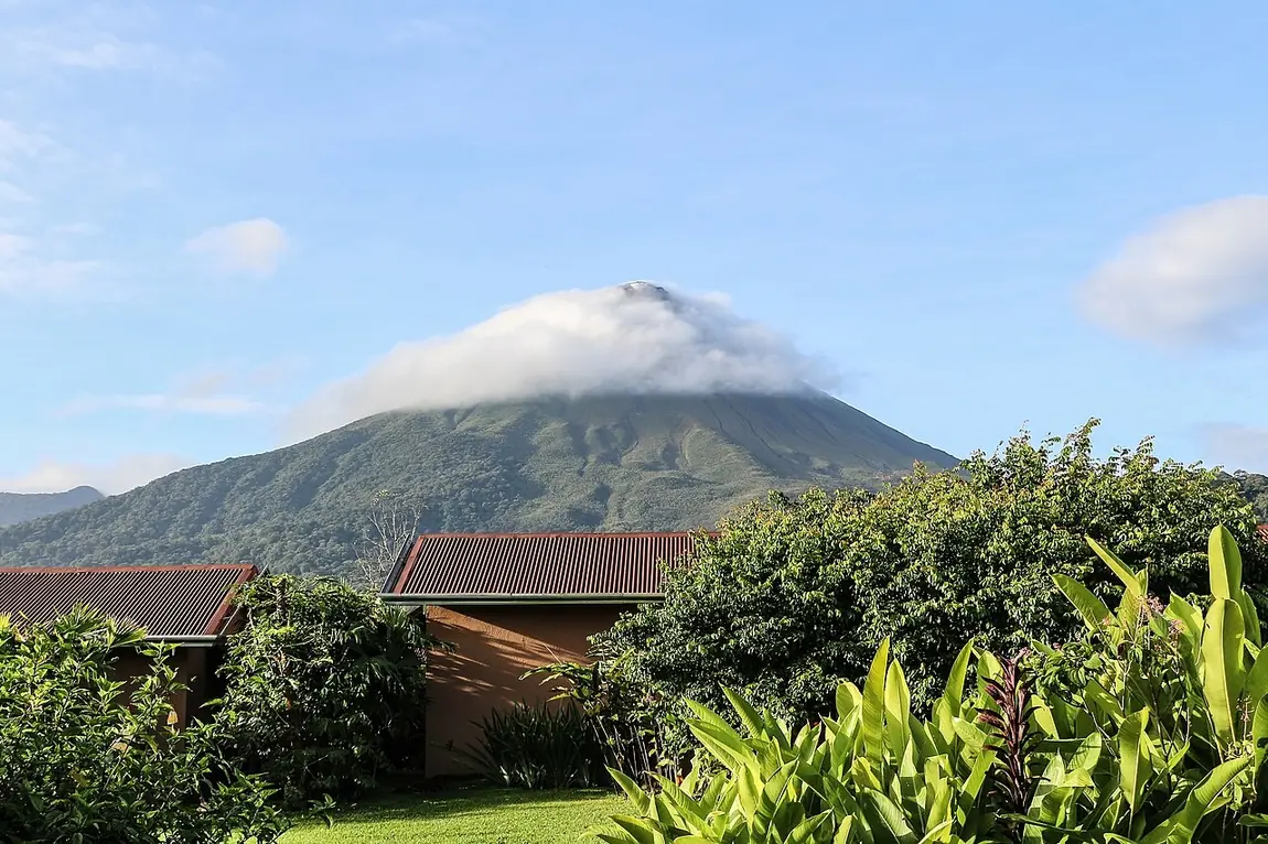 El volcán Arenal con una nube en la cima. You can visit Arenal Volcano. Foto: Bernard Gagnon, Wikimedia Commons, CC0.