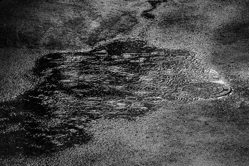 Gotas de lluvia cayendo en un charco. Ayer it was raining, so we stayed inside: estaba lloviendo y nos quedamos adentro. Foto: W.carter, Wikimedia Commons, CC BY-SA 4.0.