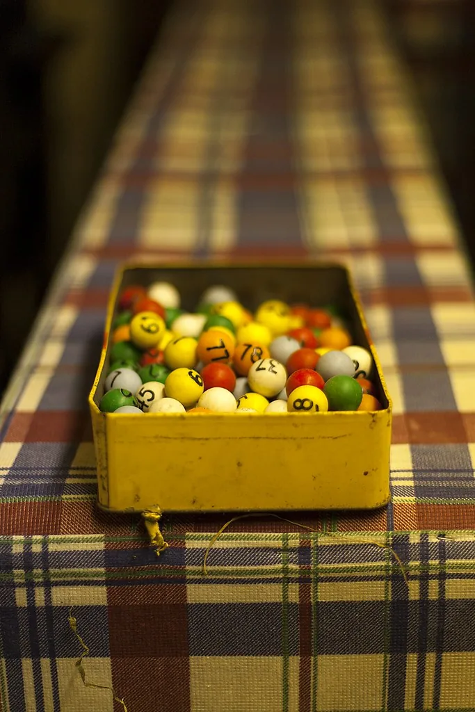 Fichas numeradas de bingo, de varios colores, en una caja de lata. Para decidir de cuál caja conviene sacar no alcanza con contar cuántas fichas del color que uno quiere hay adentro: lo que manda es qué tajada son del total, porque la probabilidad es una proporción y no una cantidad. Imagen de Flickr, leppre, licencia CC BY.