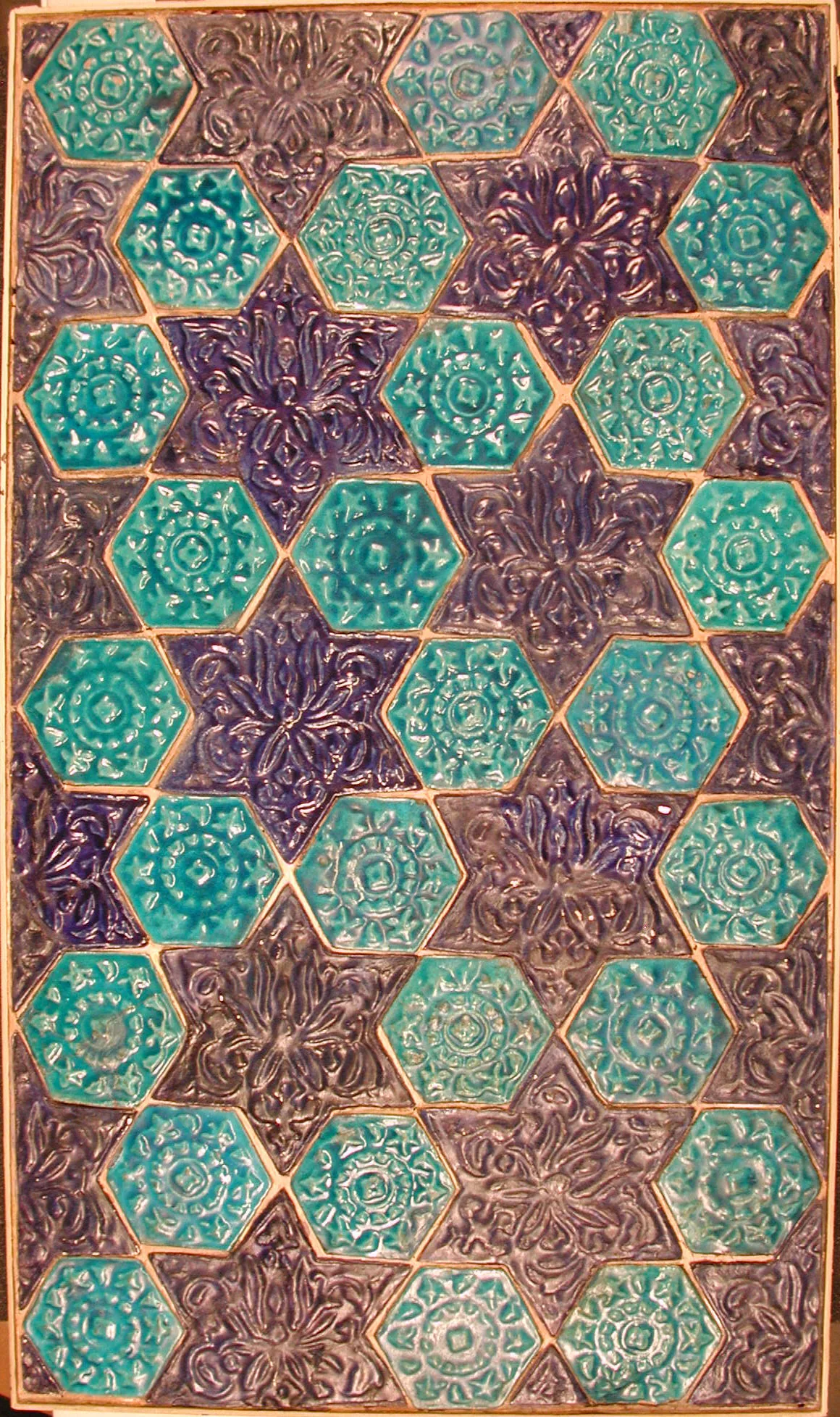 Panel de azulejos persas de los siglos XIII y XIV, armado con hexágonos turquesa y estrellas moradas de seis puntas. Las piezas se van alternando siempre con la misma regla, y esa regla es el patrón. Cuando uno la descubre puede decir qué pieza va en el lugar que sigue sin necesidad de verlo. Imagen del Museo Metropolitano de Arte de Nueva York, dominio público.
