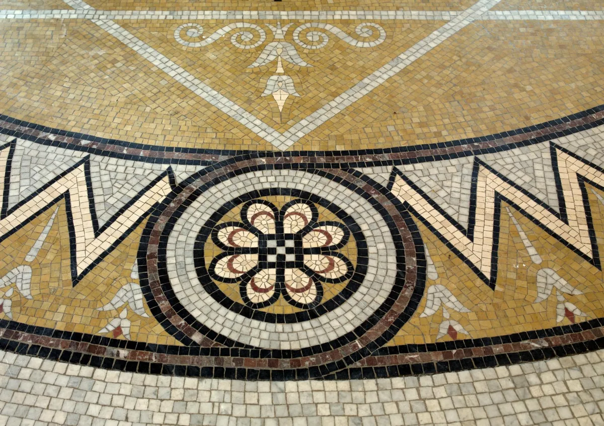 Piso de mosaico del edificio Thomas Jefferson de la Biblioteca del Congreso, en Washington. Alrededor de la flor del centro hay varios anillos, y un anillo no es una figura nueva: es un círculo grande al que se le quitó el círculo de adentro. Así se mide una figura compuesta, sumando lo que está y restando lo que falta. Fotografía de la Biblioteca del Congreso de Estados Unidos, dominio público.